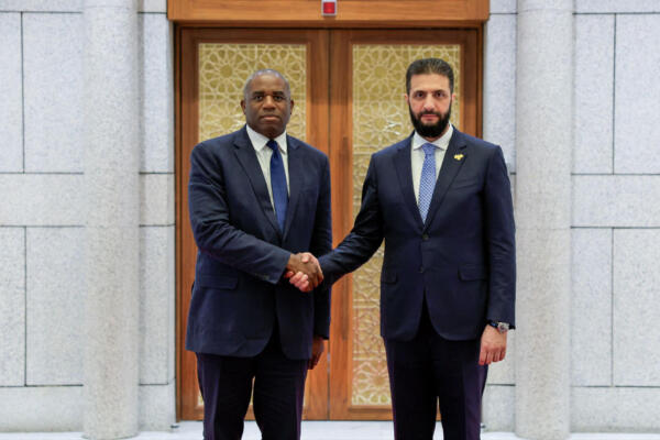 Una imagen difundida por la Agencia de Noticias Árabe Siria (SANA) muestra al presidente interino de Siria, Ahmad Al-Sharaa (der.), saludando al secretario de Relaciones Exteriores británico, David Lammy, en Damasco, el 5 de julio de 2025. (Foto: SANA / AFP) 