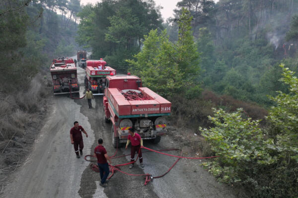 An aerial view shows Turkish firefighters preparing their hose during a forest fire in the coastal Syrian province of Latakia on July 5, 2025. Syrian emergency workers were battling forest fires raging in the coastal province of Latakia on Saturday for a third day in tough conditions as neighbouring Turkey sent assistance. Syria's ministry for emergencies and disaster management said teams from Turkey began helping on Saturday morning 