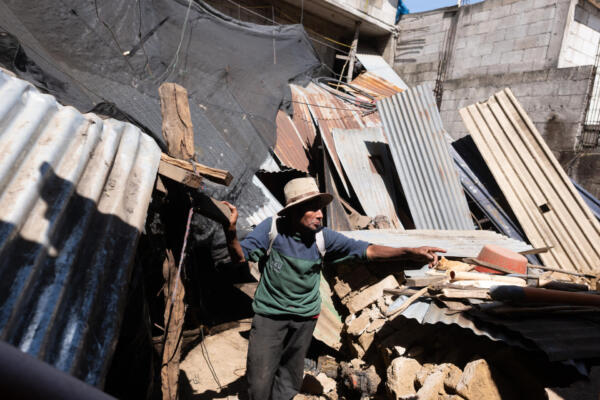 Mateo Rancho, 70, remains inside his house beside the collapsed wall of a store after a series of earthquakes rattled the area in Santa María de Jesús, Guatemala, on July 9, 2025. The swarm of earthquakes that has been affecting Guatemala since Tuesday has caused at least five deaths, affected some 650 people, and damaged around 100 homes, civil protection authorities reported on Wednesday. (Photo by Edwin Bercian / AFP)