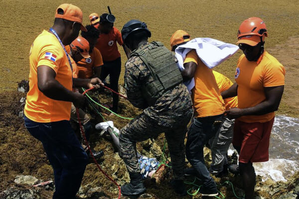 Contenido gráfico: Fuente externa / Esta imagen, publicada por la Defensa Civil de la República Dominicana, muestra a miembros de la Defensa Civil y a un miembro de la Armada recuperando el cuerpo de un náufrago en Playa Juanillo, cerca de Punta Cana, República Dominicana, el 11 de julio de 2025. 