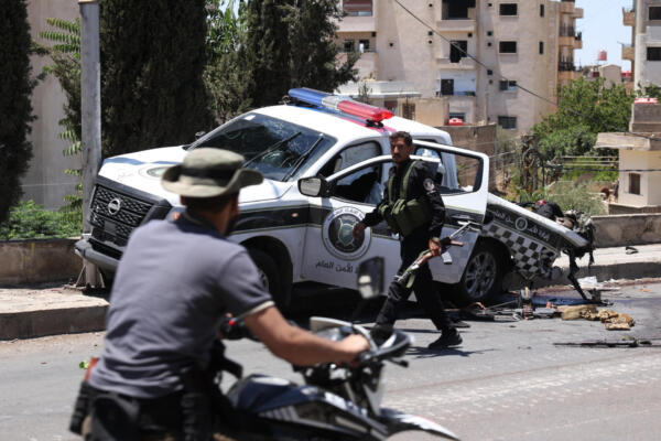 EDITORS NOTE: Graphic content / The body of a member of Syria's security forces lies in a damaged pickup truck following an Israeli strike in the predominantly Druze city of Sweida on July 15, 2025, following clashes between Bedouin tribes and Druze fighters. Israel launched strikes on July 15 against Syrian government forces in the Druze-majority region of Sweida, saying it was acting to protect the religious minority. (Photo by Bakr ALKASEM / AFP)