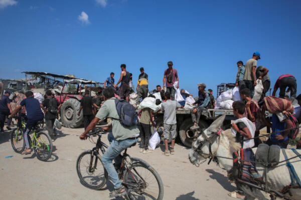 Displaced Palestinians sit on a trailer with bags of humanitarian aid they received at a distribution centre run by the US and Israeli-backed Gaza Humanitarian Foundation (GHF) at the so-called 