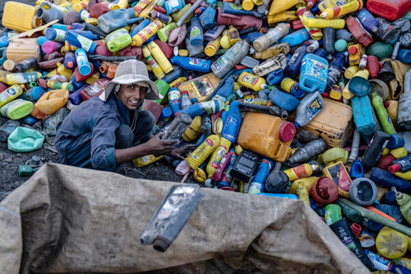 An Afghan worker sorts recyclable plastic cans at a recycling yard on the outskirts of Kabul on August 5, 2025. (Photo by Wakil KOHSAR / AFP)