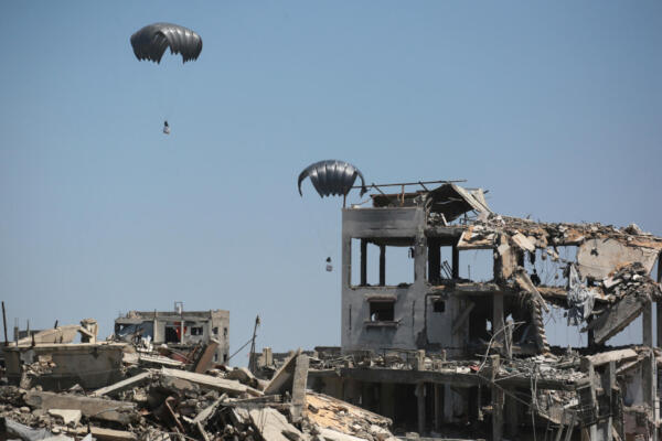 Aid pallets are parachuted after being dropped from a military plane near Jabalia in the northern Gaza Strip on August 20, 2025. Israel's defence minister approved a plan on August 20, for the conquest of Gaza City and authorised the call-up of around 60,000 reservists, piling pressure on Hamas as mediators push for a ceasefire. (Photo by BASHAR TALEB / AFP)