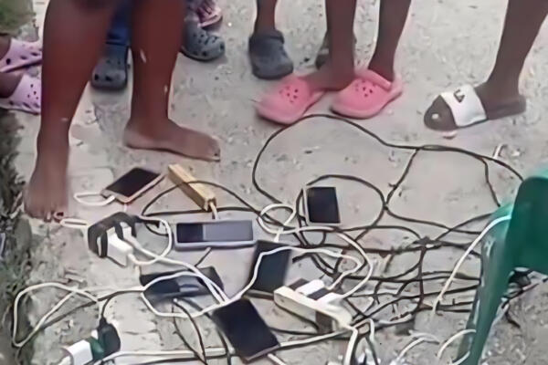 Ciudadanos cargando sus celulares en planta eléctrica comunitaria durante apagón