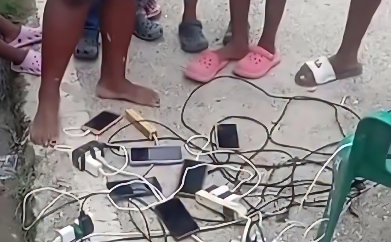 Ciudadanos cargando sus celulares en planta eléctrica comunitaria durante apagón