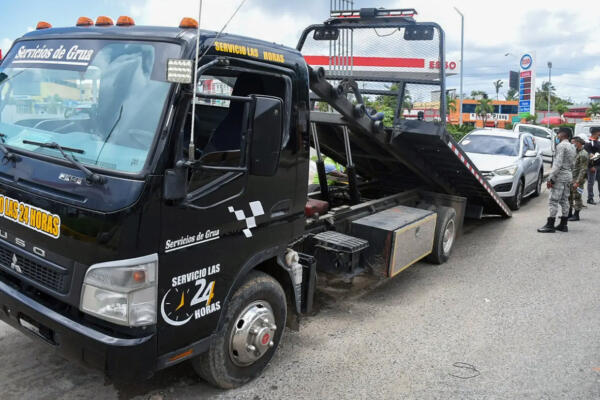 Grúa retirando un vehículo mal estacionado en Santo Domingo.