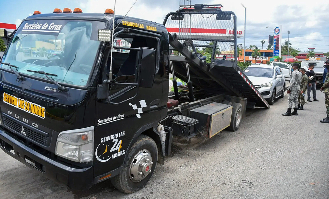 Grúa retirando un vehículo mal estacionado en Santo Domingo.