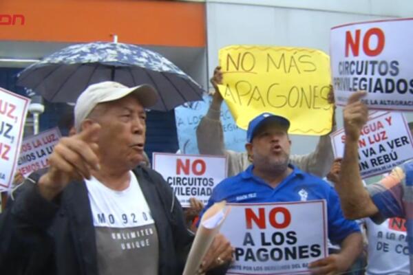 Residentes en el sector Herrera, con pancartas en manos por apagones. 