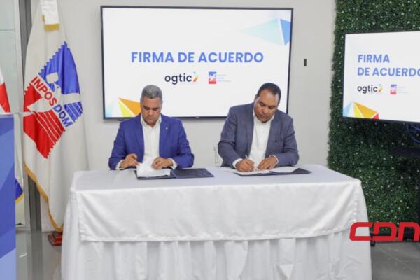 El director general de Inposdom, Eric Guzmán, y el director general de la Ogtic, Edgar Batista firmando el acuerdo para la instalación de nuevos Puntos GOB. Foto: Fuente Externa.
