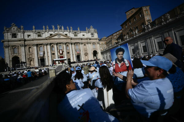 Un fiel sostiene un retrato del difunto adolescente Carlo Acutis frente a la Basílica de San Pedro, antes de la Santa Misa y la ceremonia de canonización de los beatos Carlo Acutis y Pier Giorgio Frassati en la Plaza de San Pedro del Vaticano, el 7 de septiembre de 2025. (Foto: AFP)