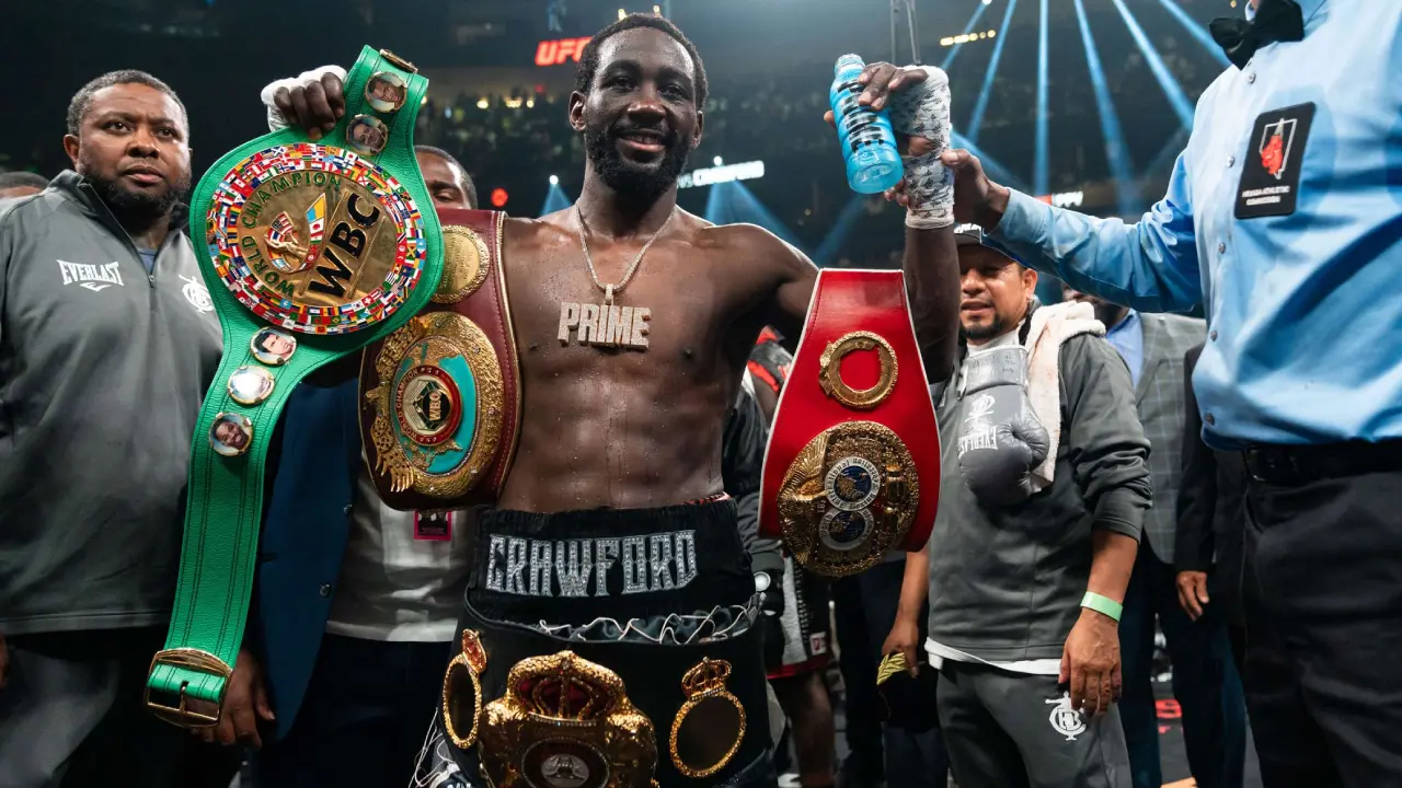 Crawford celebra con los cinturones tras vencer a Canelo
