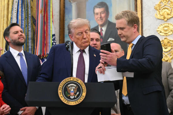 El reportero de Fox News, Peter Doocy, muestra su teléfono al presidente estadounidense Donald Trump mientras hace un anuncio en la Oficina Oval de la Casa Blanca en Washington, D.C., el 2 de septiembre de 2025. (Foto de SAUL LOEB / AFP)
