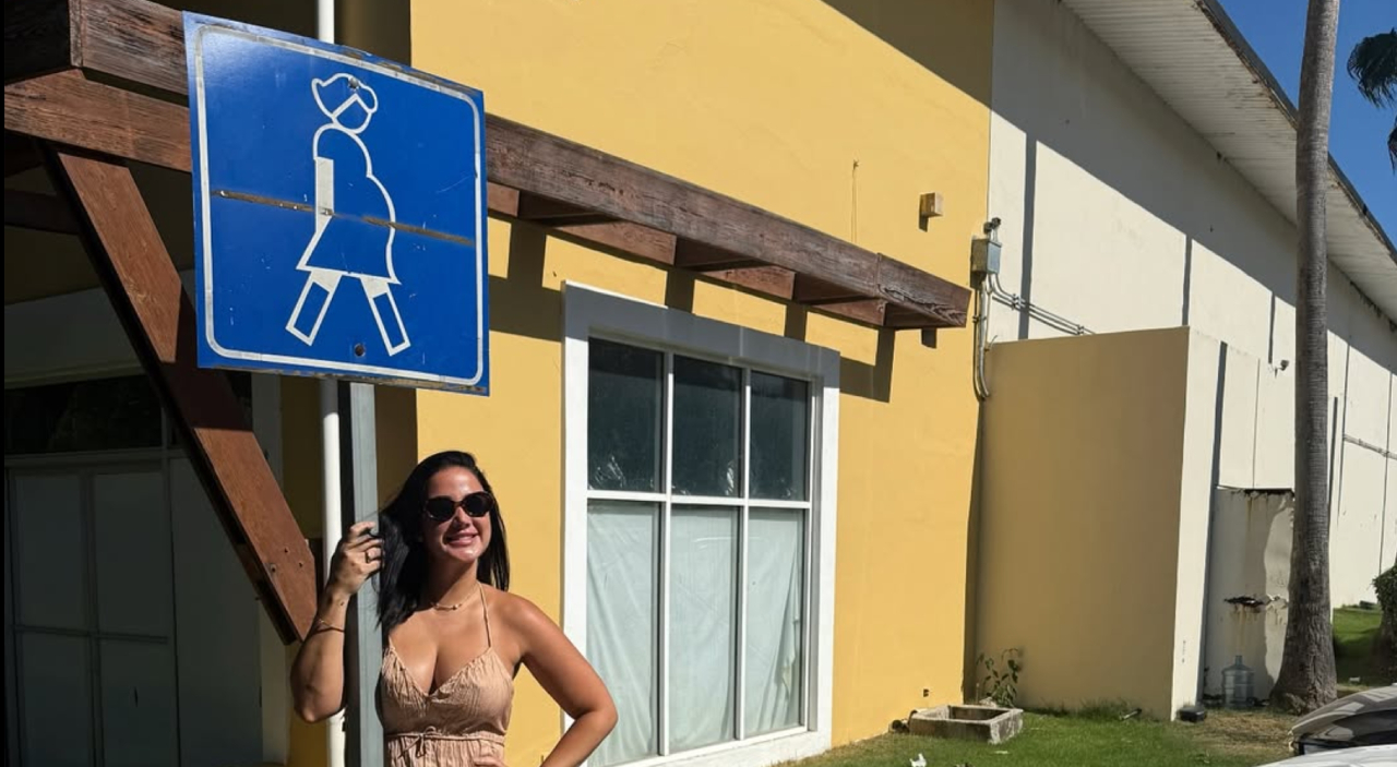 Larimar Fiallo junto a señal de parqueo para embarazadas al anunciar embarazo