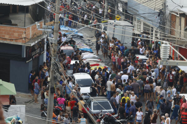 Personas observan cuerpos sin vida en una calle este miércoles, en Río de Janeiro (Brasil). EFE/ Antonio Lacerda