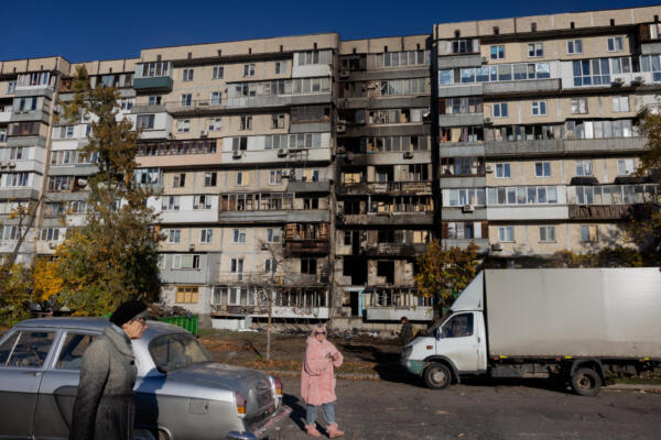 Residentes locales pasan junto a un edificio residencial dañado tras un ataque con drones en Kiev, el 26 de octubre de 2025, en medio de la invasión rusa de Ucrania / Foto: AFP