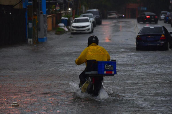 Delivery operando bajo lluvia en Santo Domingo 