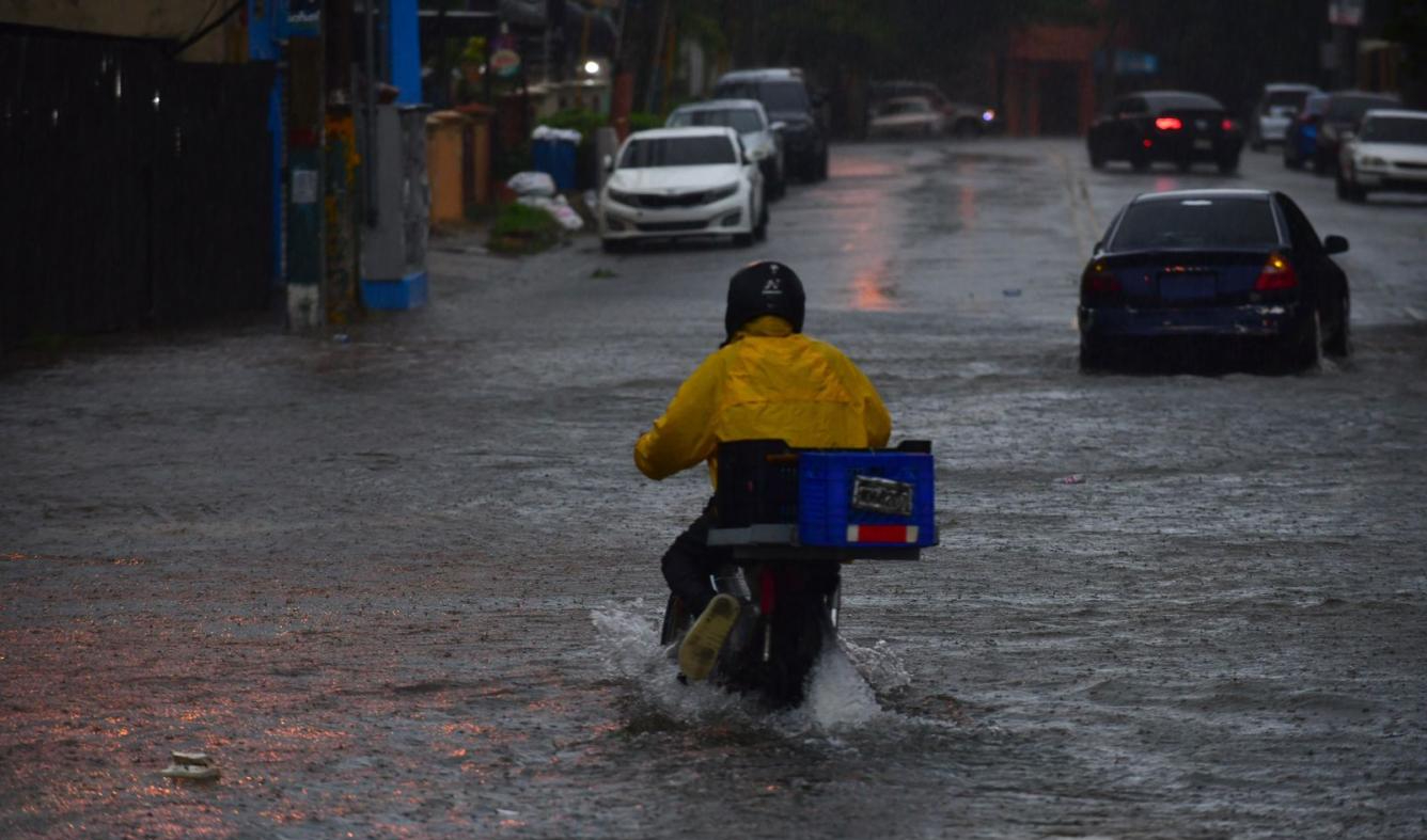 Delivery operando bajo lluvia en Santo Domingo