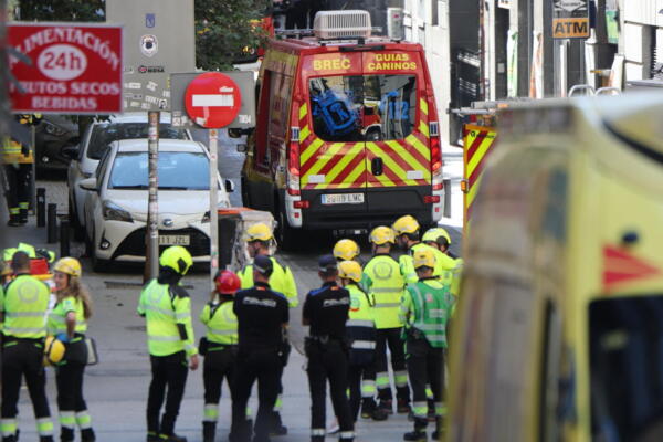 Police and emergency service workers gather near the site of a building collapse in Madrid on October 7, 2025. Spanish emergency services scrambled to a building collapse in Madrid's touristic city centre on Tuesday with local media reporting several people missing. Emergency services said on X that firefighters were working at the scene of a building undergoing refurbishment near the Spanish capital's opera. (Photo by Thomas COEX / AFP)