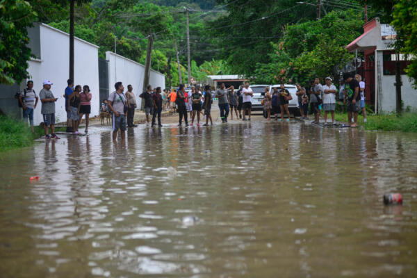 Personas en una calle inundada tras las fuertes lluvias en Poza Rica, Veracruz, México, el 10 de octubre de 2025. Las fuertes lluvias del 9 de octubre de 2025 en México causaron dos muertes, además de inundaciones de viviendas, deslizamientos de tierra y el desbordamiento de ríos en varias partes del país, informó el gobierno mexicano el viernes. (Foto de Marco Antonio Pérez / AFP)