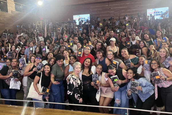 Eva Muñoz (en el centro, con con blusa negra bajo bleiser blanco) rodeada de lectoras en la Feria de Libro 2025
