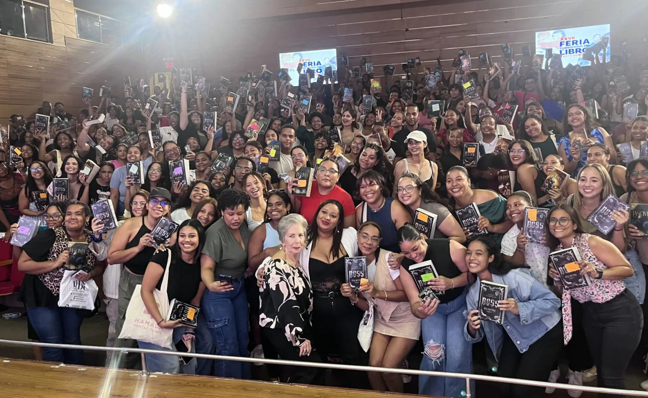 Eva Muñoz (en el centro, con con blusa negra bajo bleiser blanco) rodeada de lectoras en la Feria de Libro 2025