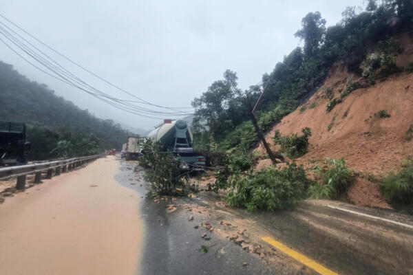 Esta fotografía, tomada y difundida por la Agencia de Noticias de Vietnam (VNA) el 17 de noviembre de 2025, muestra vehículos atrapados en una carretera dañada tras los deslizamientos de tierra provocados por las intensas lluvias, cerca del lugar donde un autobús de pasajeros quedó sepultado por la caída de tierra y rocas en el paso de Khanh Le, en la provincia de Khanh Hoa. (Foto de Vı Xuân Triıu / Agencia de Noticias de Vietnam (VNA) / AFP)