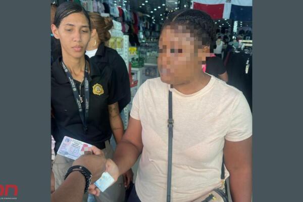 Agentes de la DGM verifican los datos de identidad de una nacional haitiana durante un operativo en Santiago. Foto: Fuente externa