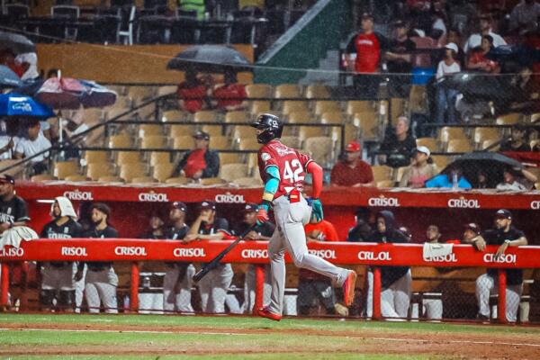 Julio Carreras al momento que celebra su jonrón con las bases llenas para ayudar a los Gigantes a vencer a los Leones del Escogido en la Pelota Invernal