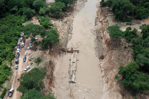 Una vista aérea muestra el colapso de un puente tras el desbordamiento del río Piraí debido a las fuertes lluvias en El Torno, departamento de Santa Cruz, Bolivia, el 14 de diciembre de 2025. Al menos 20 personas murieron y decenas siguen desaparecidas después de que un importante río en el este de Bolivia se desbordara el fin de semana tras las fuertes lluvias, informaron las autoridades el 15 de diciembre. (Foto de Rodrigo URZAGASTI / AFP)
