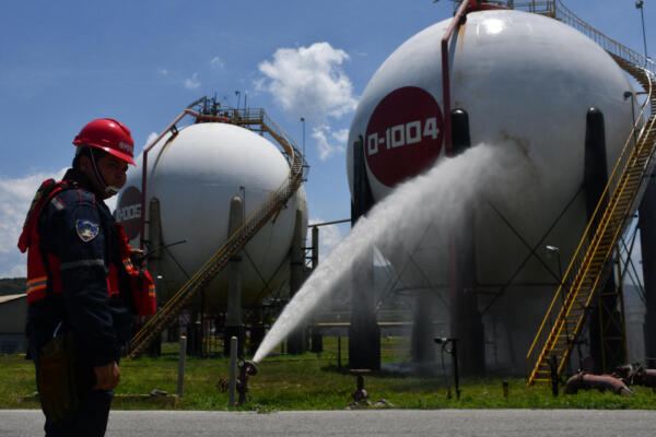 A worker of the Venezuelan state oil company PDVSA participates in a drill to reduce risks from natural disasters or armed conflicts at the El Palito refinery in Puerto Cabello, Carabobo State, Venezuela, on September 27, 2025. Venezuela conducted new military exercises and an emergency response drill on Saturday amid fears of a possible invasion by the United States, which has deployed an armed flotilla to the Caribbean. (Photo by AFP)