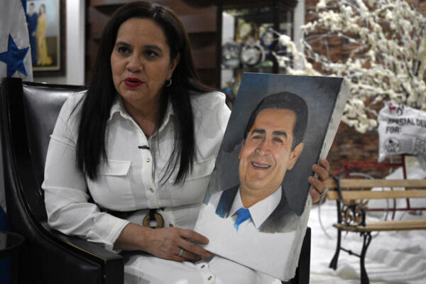 Ana García de Hernández, esposa del expresidente hondureño Juan Orlando Hernández, sostiene un retrato de su esposo durante una entrevista con AFP en Tegucigalpa el 2 de diciembre de 2025. 