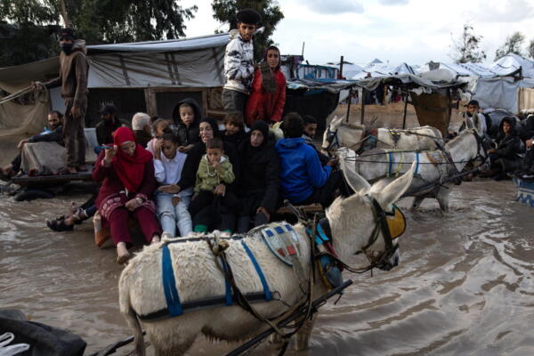 Palestinos se desplazan en carros tirados por animales por una calle inundada tras las fuertes lluvias de este 11 de diciembre de 2025, en Jan Yunis (Gaza). EFE/ Haitham Imad
