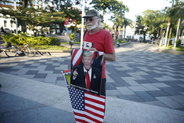 Un hombre sostiene una fotografía del presidente de Estados Unidos, Donald Trump, durante una manifestación en la plaza Simón Bolívar este sábado, en San Salvador (El Salvador). EFE/ Rodrigo Sura