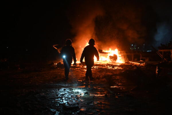 Bomberos ucranianos trabajan en una terminal de la empresa postal Nova Poshta, gravemente dañada tras un ataque aéreo. // Foto: AFP