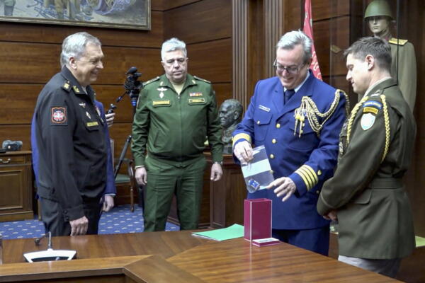 Una imagen fija tomada de un vídeo facilitado por el servicio de prensa del Ministerio de Defensa ruso muestra al jefe de la Dirección Principal de Inteligencia del Estado Mayor de las Fuerzas Armadas rusas, el almirante Igor Kostyukov (izquierda), mientras entrega los datos de ruta descifrados y el controlador del dron derribado por las fuerzas de defensa aérea rusas el 29 de diciembre sobre la región de Nóvgorod a un representante de la oficina del agregado militar de la embajada de Estados Unidos en Moscú, Rusia, el 1 de enero de 2026. 