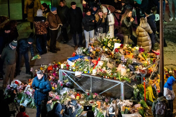 Los dolientes se reúnen en un monumento improvisado cerca del lugar donde se incendió un bar durante las celebraciones de Nochevieja en la estación de esquí alpina de Crans-Montana, el 2 de enero de 2026. El incendio causó la muerte de unas 40 personas y dejó más de 100 heridos. (Foto de MAXIME SCHMID / AFP)
