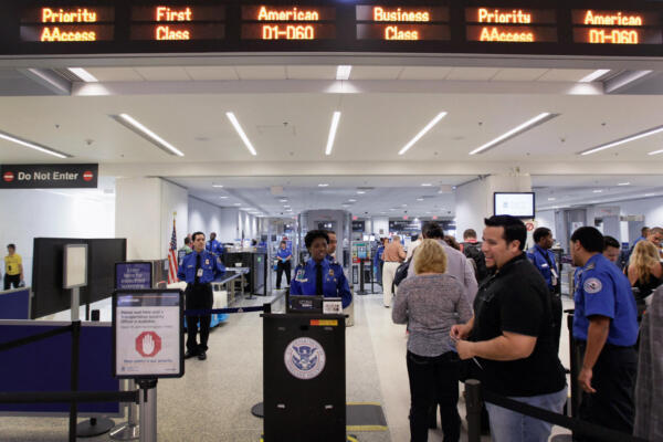FOTO DE ARCHIVO | Pasajeros esperan para pasar el control de seguridad junto a la recién inaugurada fila TSA PreCheck (a la izquierda), implementada por la Administración de Seguridad en el Transporte (TSA) para reducir el tiempo que los pasajeros preseleccionados deben esperar en la fila de seguridad tradicional en el Aeropuerto Internacional de Miami el 4 de octubre de 2011 en Miami, Florida. Joe Raedle/Getty Images/AFP (Foto de JOE RAEDLE / GETTY IMAGES NORTH AMERICA / Getty Images vía AFP)
