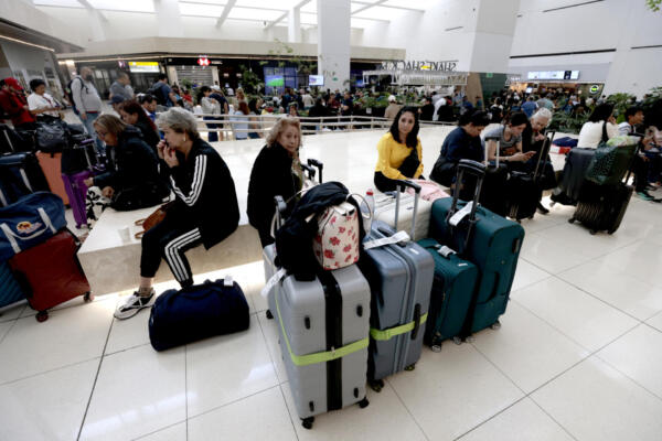 Pasajeros permanecen varados en el Aeropuerto Internacional de Guadalajara tras la suspensión de vuelos y la falta de transporte en Tlajomulco, Jalisco, México, el 22 de febrero de 2026. (Foto de Ulises Ruiz / AFP)