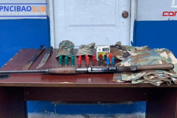 Armas, municiones y prendas militares ocupadas durante un allanamiento ejecutado por la Policía Nacional en el distrito municipal San José del Puerto, Villa Altagracia.
