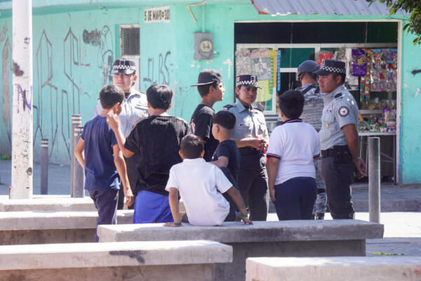 Policías mexicanos conversan con niños un día después de un ataque armado en un parque infantil en San Francisco del Rincón, Guanajuato, México, el 18 de febrero de 2026. (Foto de MARIO ARMAS / AFP)