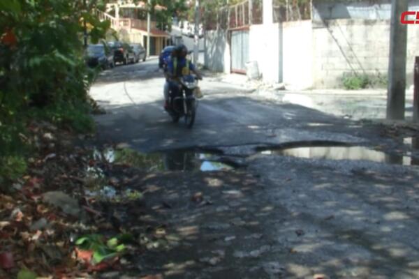Residentes de Villa Aura y El Olimpo muestran el deterioro de sus calles, donde los hoyos, el lodo y las aguas acumuladas dificultan el tránsito y ponen en riesgo a conductores y peatones en Santo Domingo Oeste.