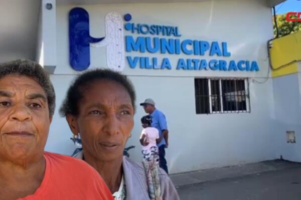 Ex trabajadoras del hospital de la Maternidad de Villa Altagracia muestran documentos médicos mientras denuncian su desvinculación y la falta de entrega de papeles para tramitar su pensión.