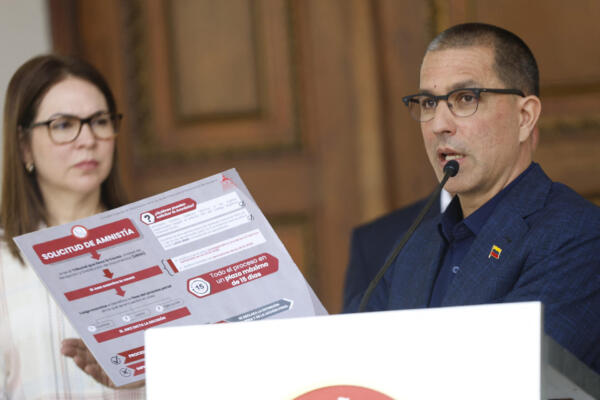 Jorge Arreaza, presidente de la Comisión Especial para el Desarrollo e Implementación de los Mecanismos de la Ley de Amnistía para la Convivencia Democrática, muestra un cartel con los pasos a seguir para solicitar la Ley de Amnistía en la Comisión de Seguimiento de la Asamblea Nacional de Venezuela, tras una reunión en la sede del Congreso Nacional en Caracas el 24 de febrero de 2026. (Foto: Pedro MATTEY / AFP)
