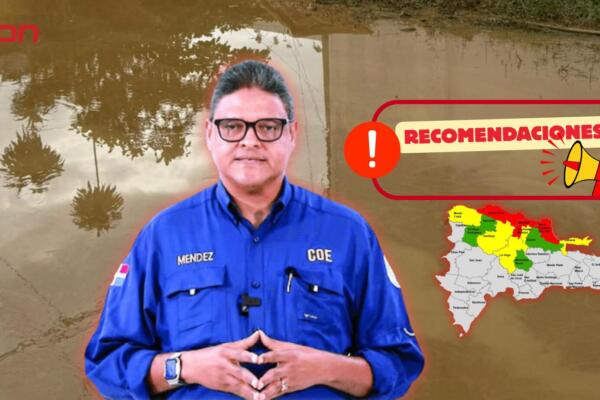 Ciudadanos transitan con precaución por una zona anegada en el Cibao, mientras el Centro de Operaciones de Emergencias (COE) mantiene alertas activas y difunde orientaciones preventivas ante las inundaciones.