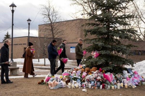 La gente trae flores y presenta sus respetos en una vigilia comunitaria en Tumbler Ridge dos días después de que la comunidad rural experimentara uno de los tiroteos más letales de Canadá el 12 de febrero de 2026. (FOTO: AFP) 