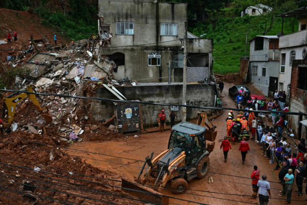 Equipos de rescate buscan víctimas entre los escombros tras un deslizamiento de tierra causado por las fuertes lluvias en el Barrio Parque Jardim Burnier en Juiz de Fora, Minas Gerais, Brasil, el 24 de febrero de 2026. (Foto de Pablo PORCIUNCULA / AFP)