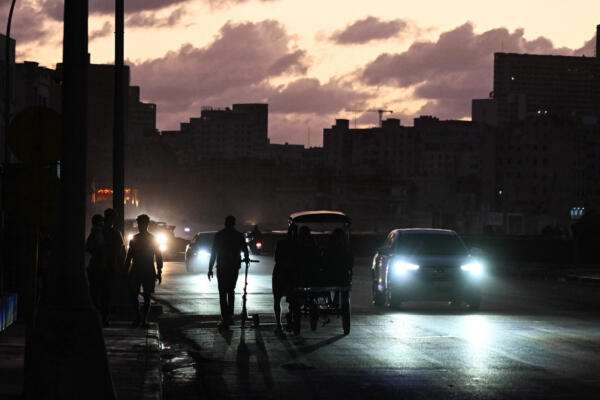 La gente transita por una calle sin luz durante un apagón nacional en La Habana el 21 de marzo de 2026.