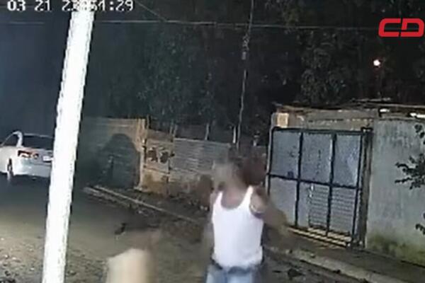 Momento de la grabación de la cámara de seguridad en donde la mujer cae al suelo en medio de la agresión por parte del hombre en Santiago. Foto: CDN Digital