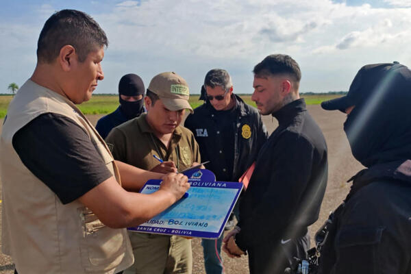 Fotografía distribuida por la Secretaría Nacional Antidrogas de Paraguay (SENAD) del presunto narcotraficante uruguayo Sebastián Marset (2.º por la derecha) tras su detención por agentes de la DEA en el aeropuerto Viru Viru de Santa Cruz, Bolivia, el 13 de marzo de 2026. (FOTO: AFP) 